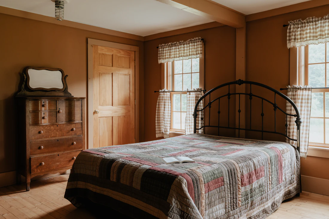 A bed between two windows