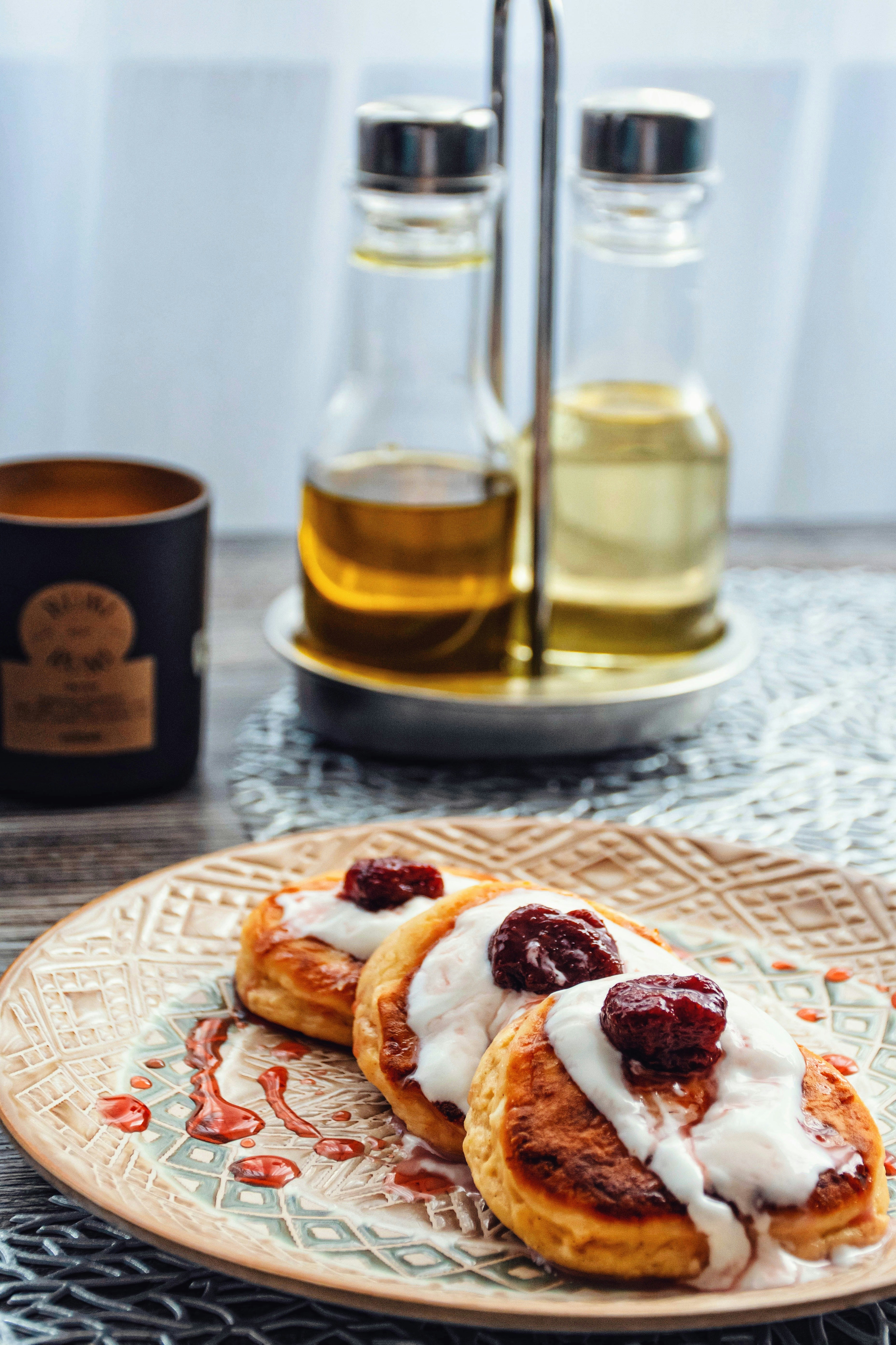 Ein Teller mit Pfannkuchen und Zuckerguss neben einer Tasse Tee