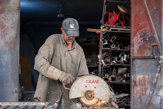 A man cutting a piece of metal with a circular saw