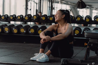 A woman sitting on the ground in a gym