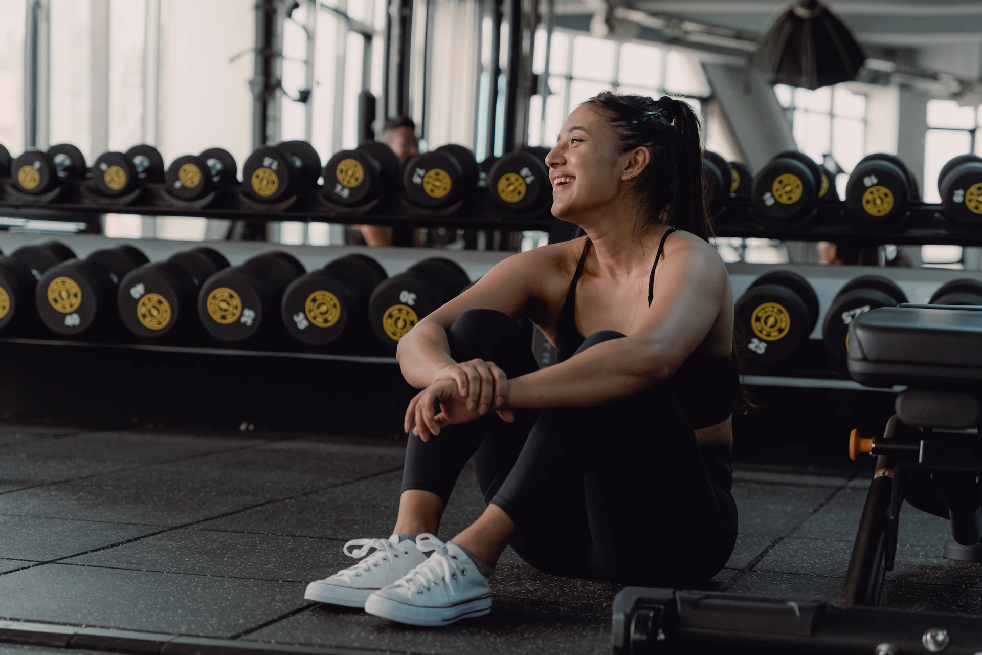 A woman sitting on the ground in a gym