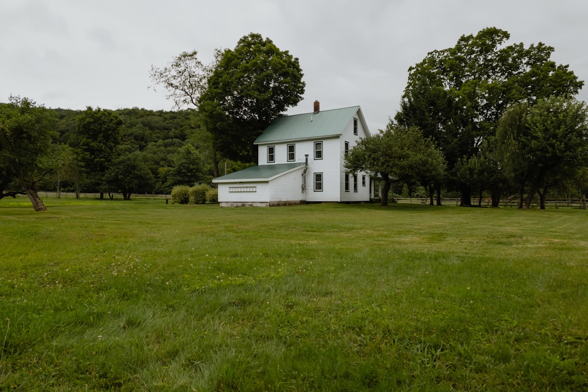 A white house sitting on top of a lush green field