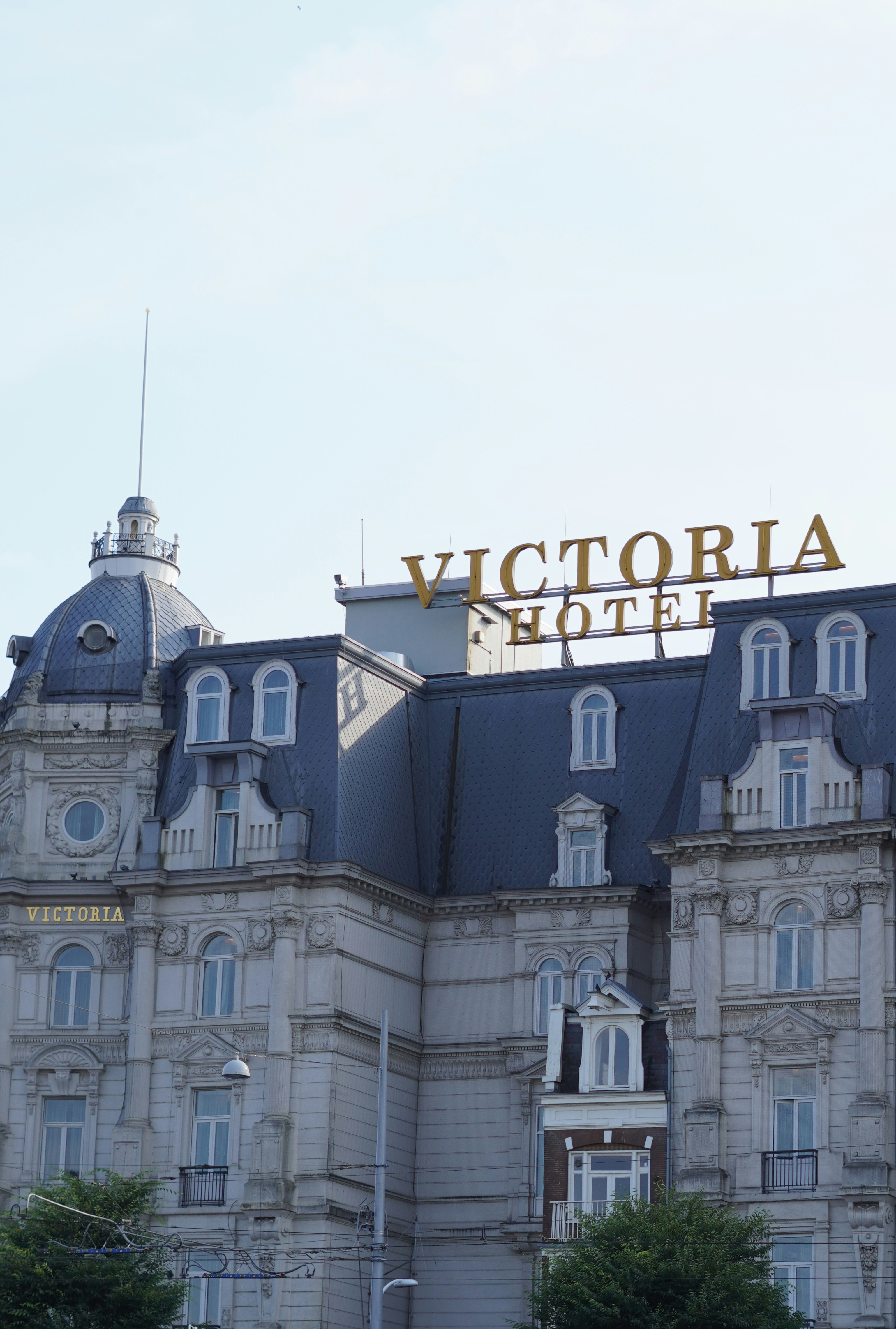 A large building with a sign on top of it photo – Free City Image on ...