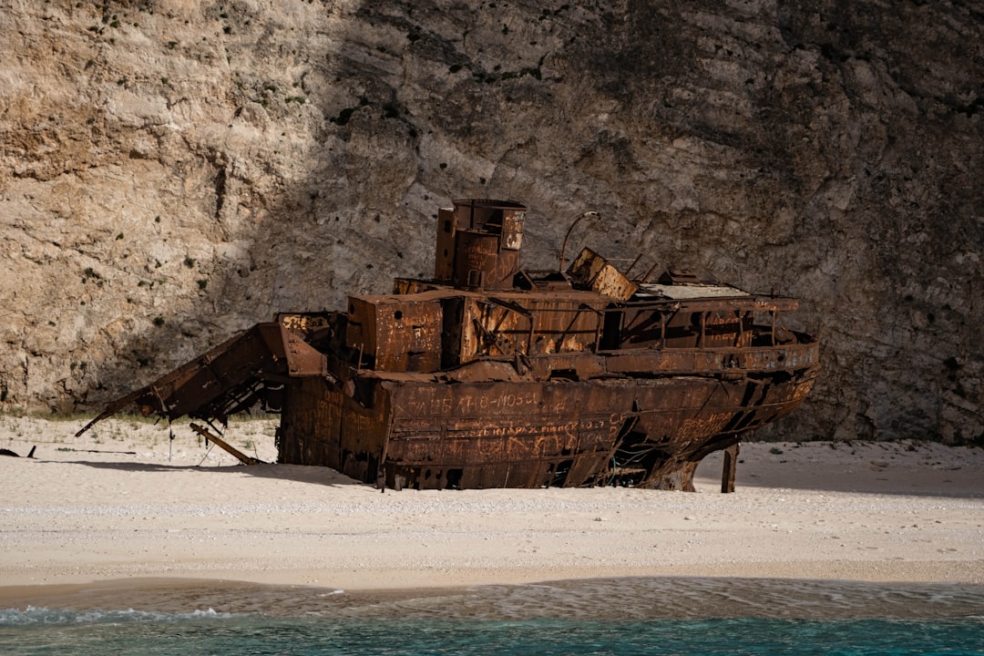 A wooden boat sitting on top of a sandy beach