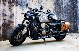 A black and silver motorcycle parked in front of a wall