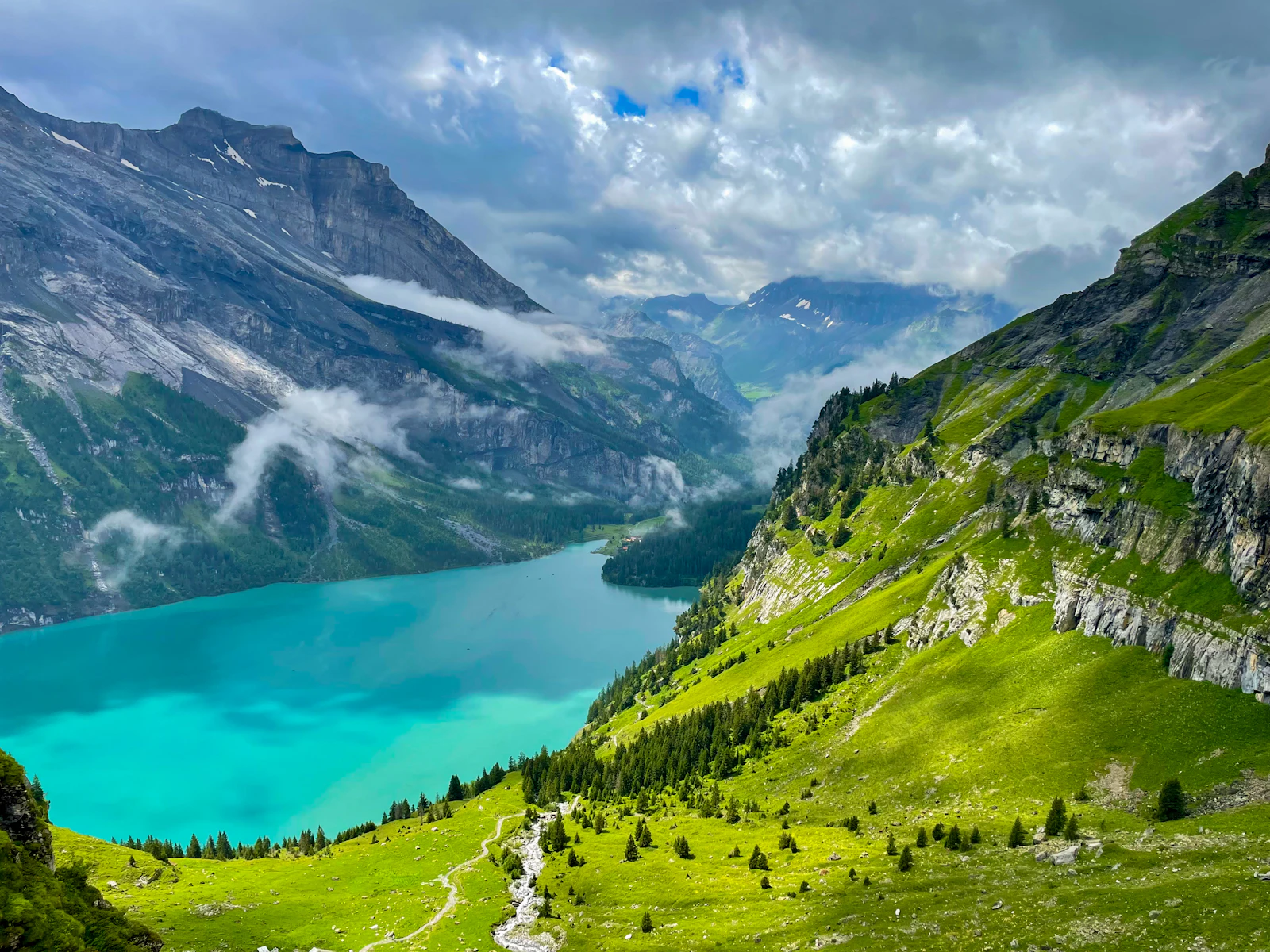 Turquoise mountain lake below high Swiss ridges