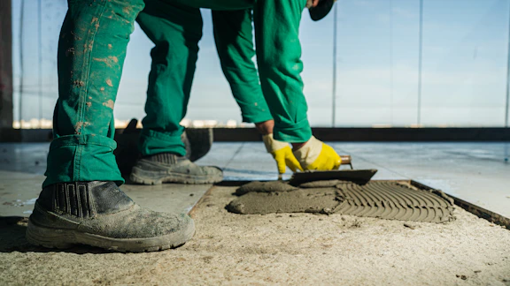A person in green pants and yellow shoes