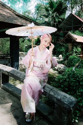 A woman sitting on a bench holding an umbrella