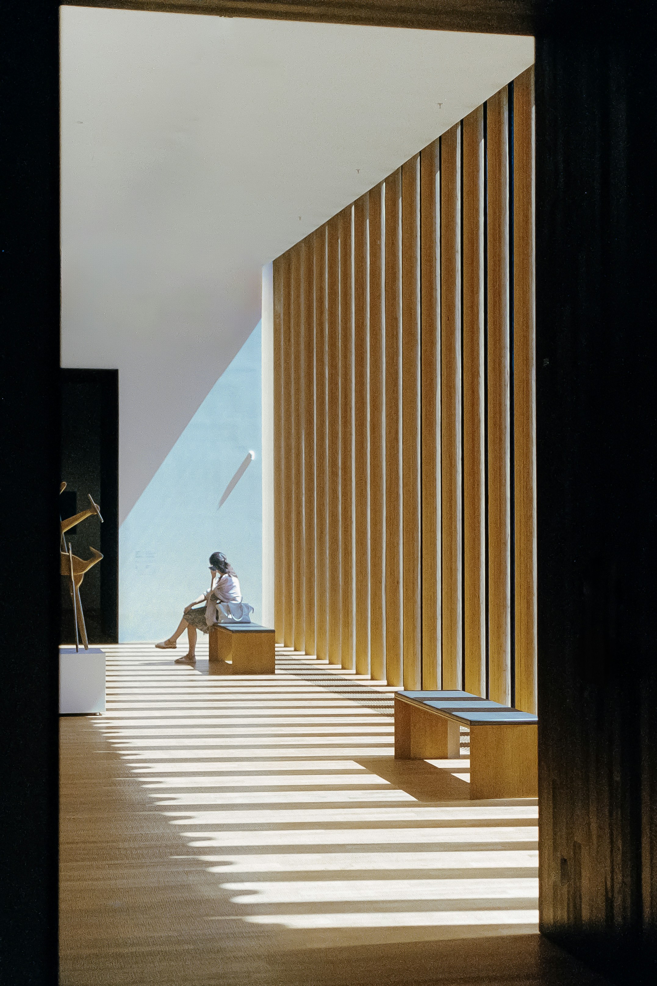 A person sitting on a bench in a room