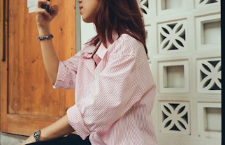 A woman sitting on the ground taking a picture with her cell phone