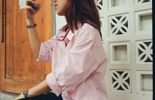 A woman sitting on the ground taking a picture with her cell phone