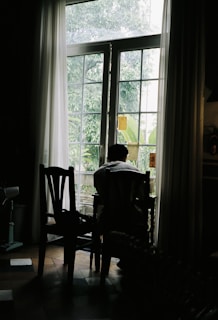 A person sitting at a table in front of a window