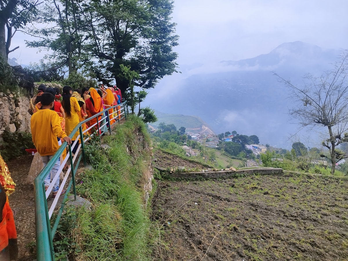 A long line of pilgrims walking uphill on a Himalayan mountain path