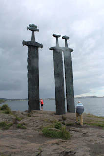 A couple of tall metal sculptures sitting on top of a beach