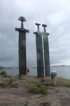 A couple of tall metal sculptures sitting on top of a beach