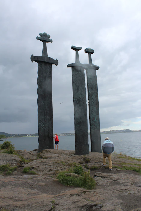 A couple of tall metal sculptures sitting on top of a beach