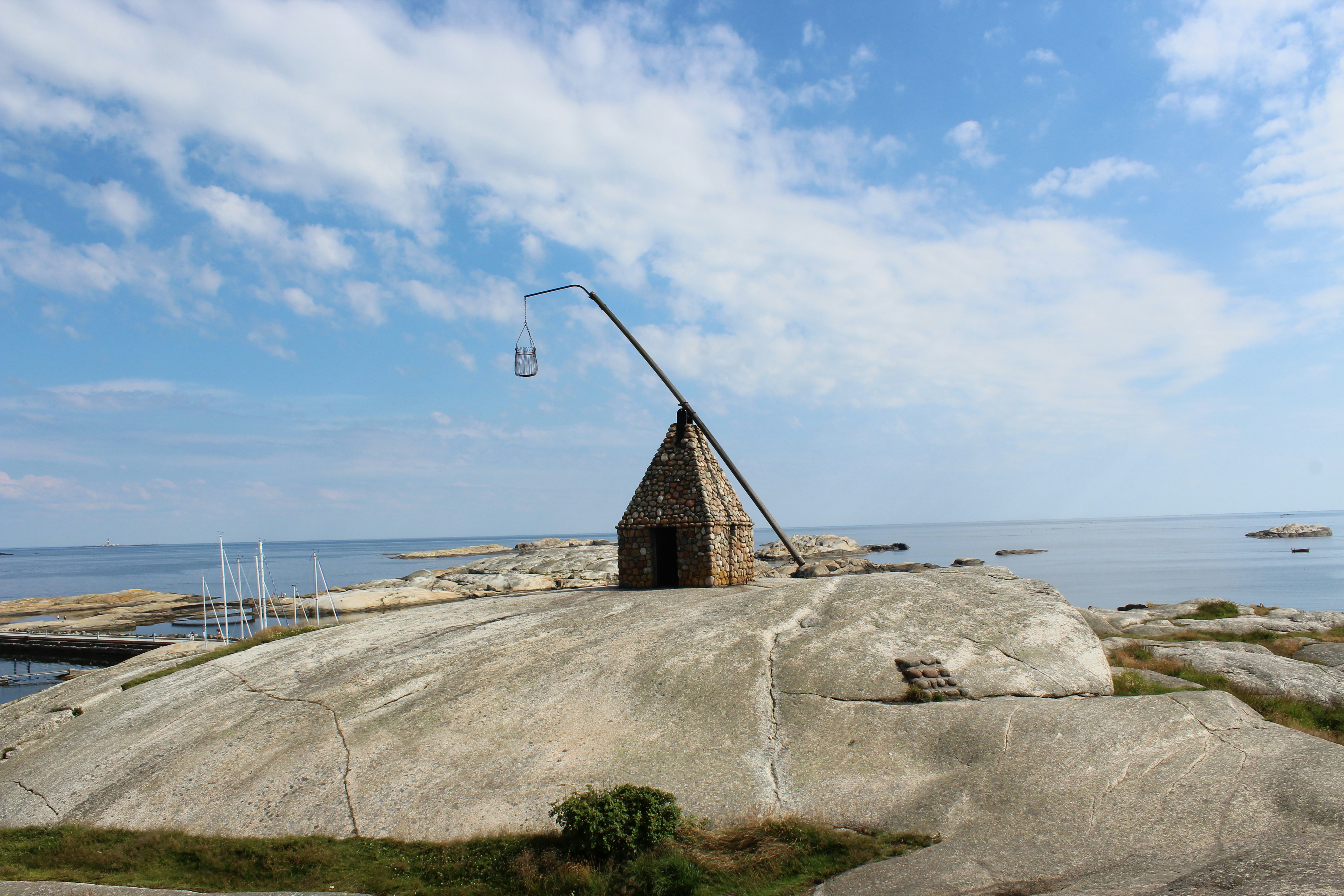A rock outcropping on a beach with a fishing pole sticking out of