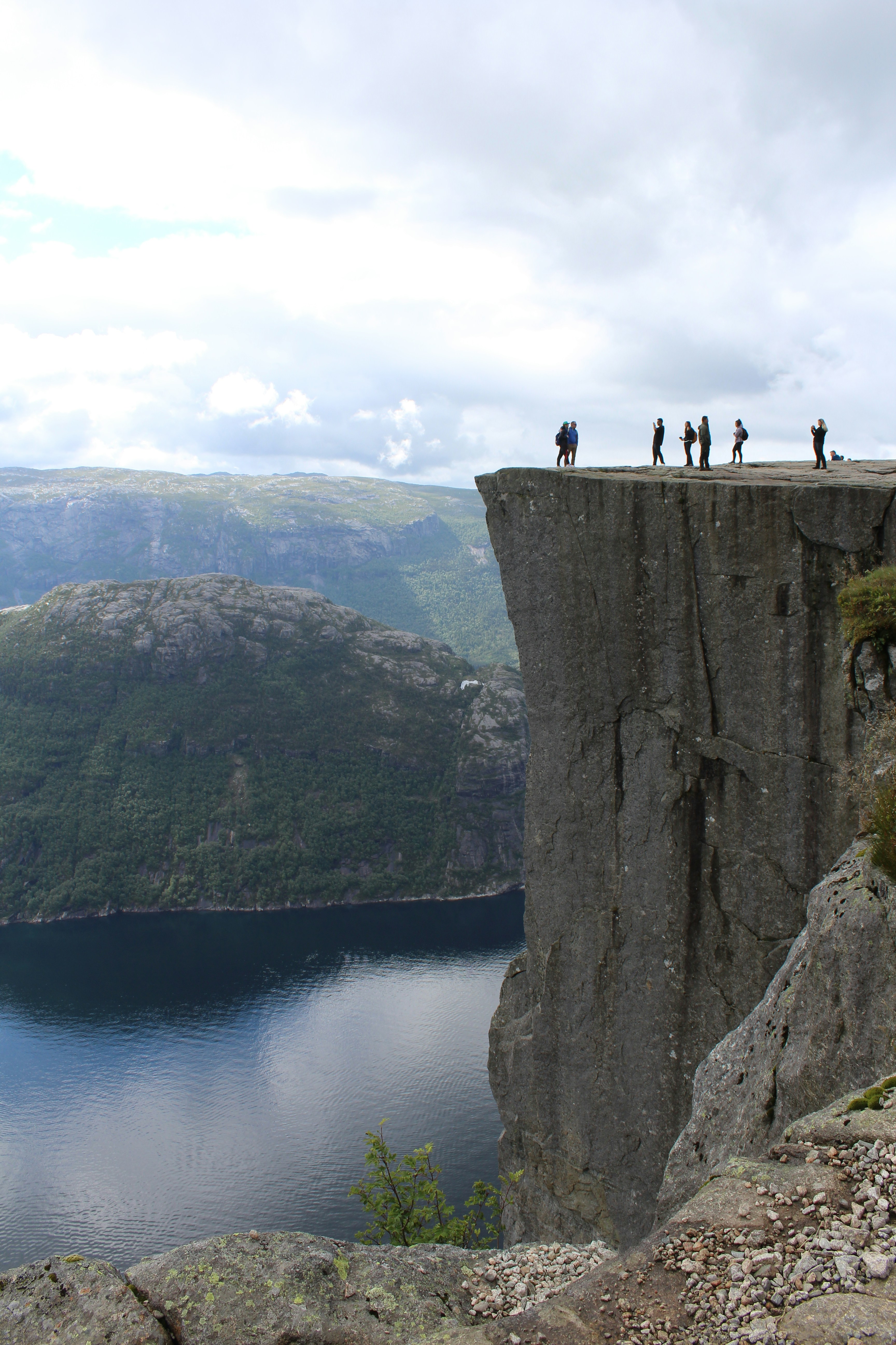 A group of people standing on top of a cliff photo – Free Mountains ...