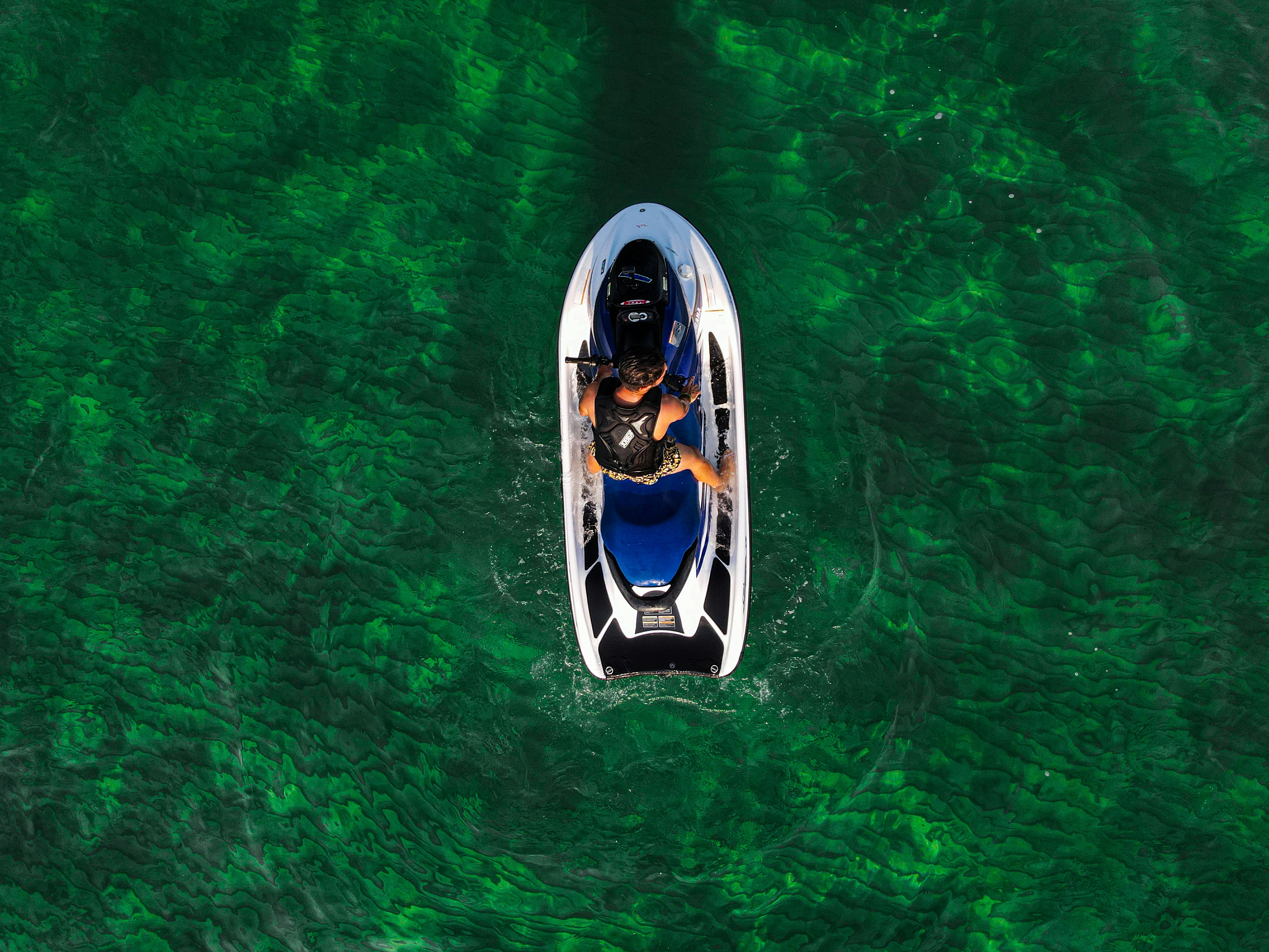 A man riding in a boat on top of green water