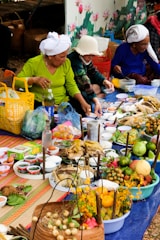 A group of people standing around a table filled with food