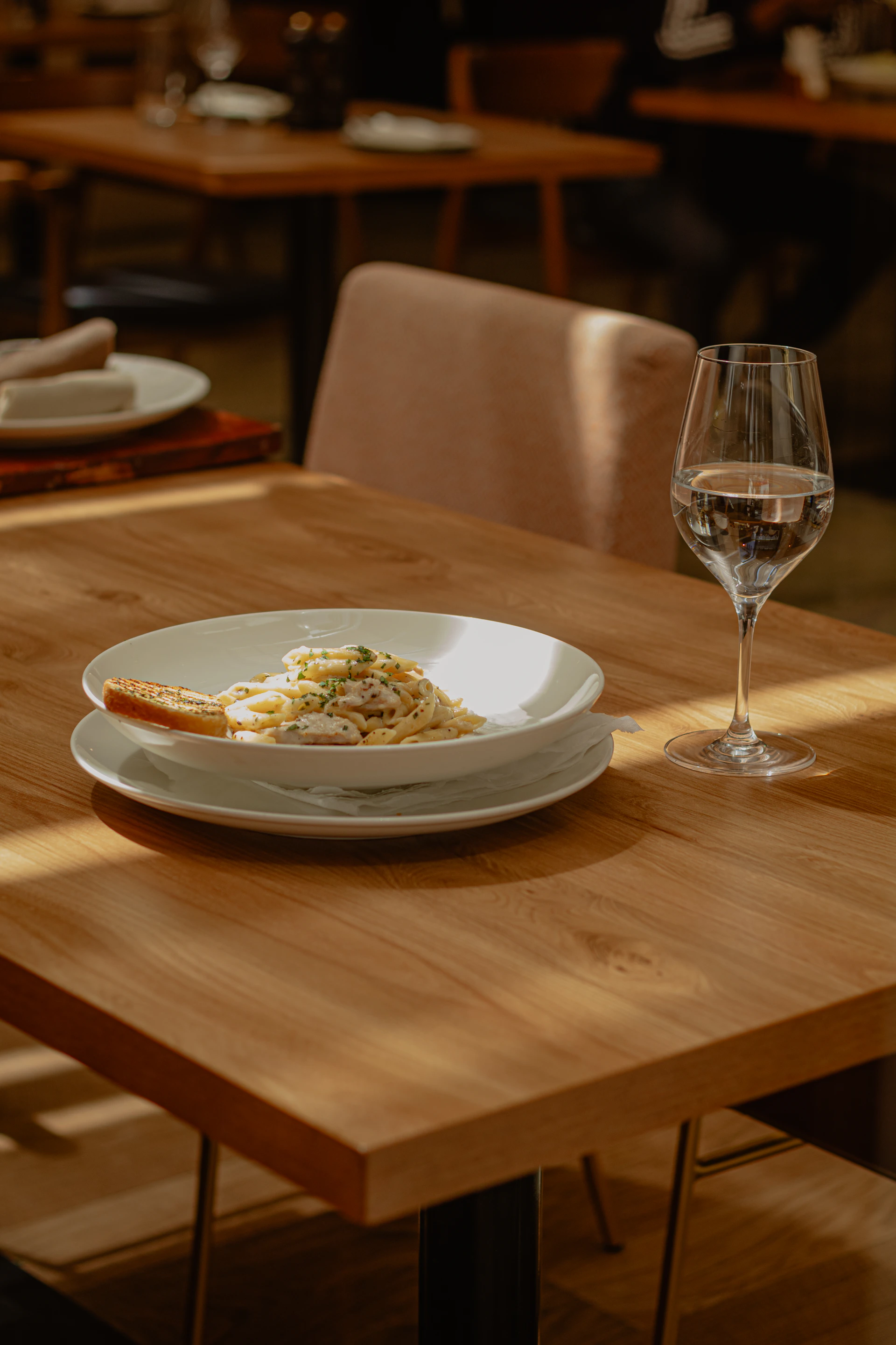 A plate of food and a glass of wine on a table