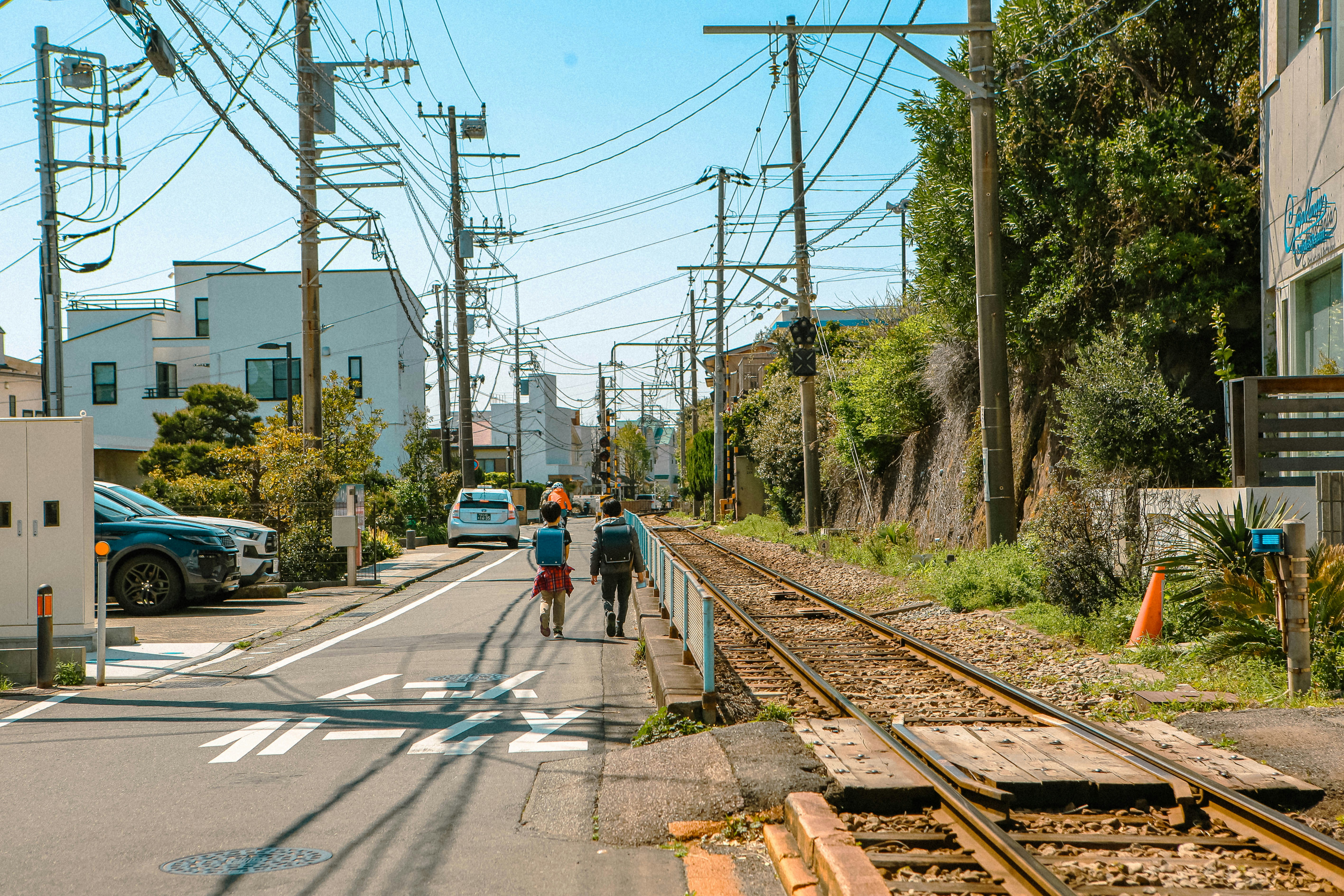 Group walking down a path alongside train tracks, evoking the film's central journey along the rail line