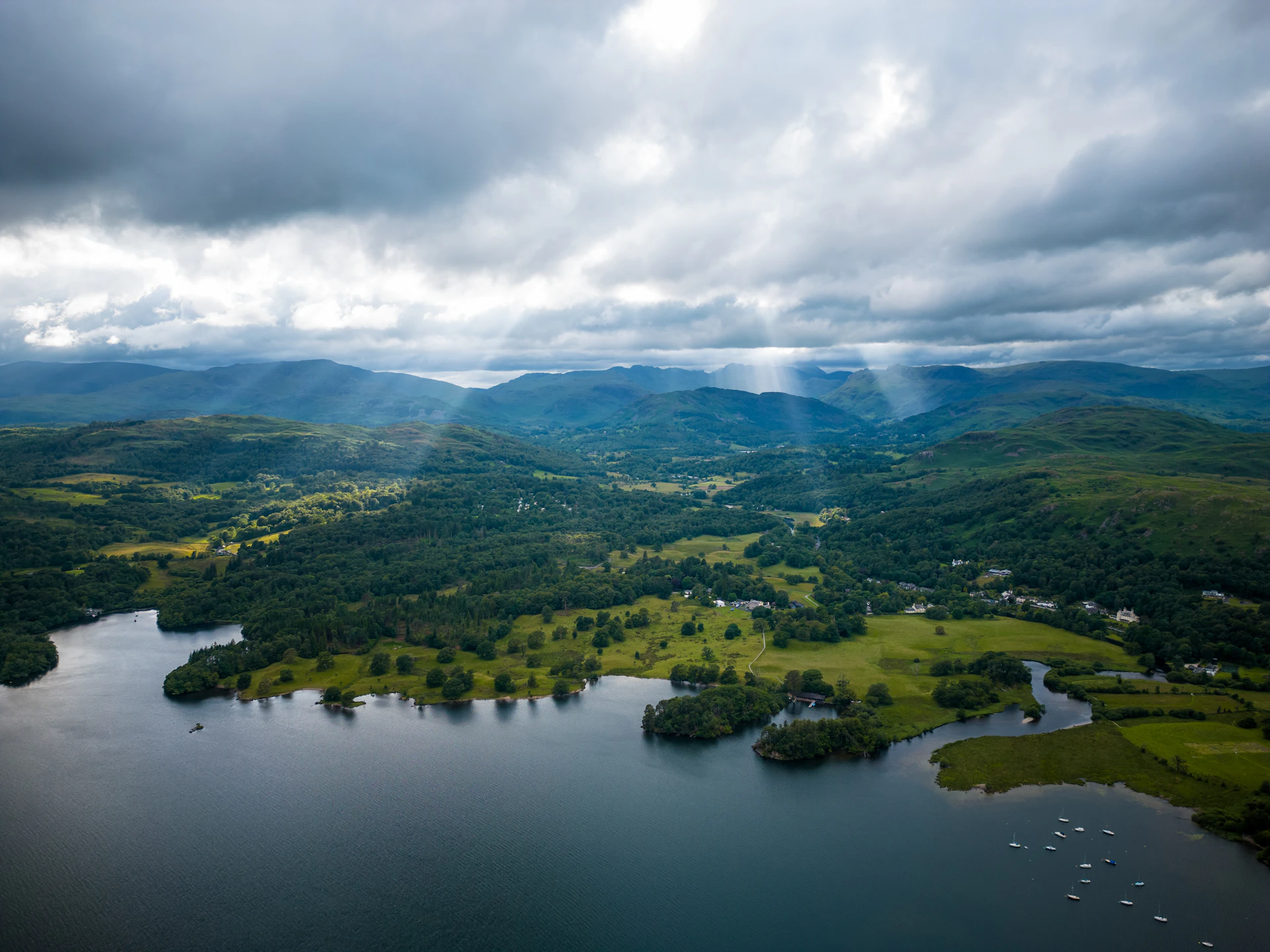 A lake surrounded by mountains under a cloudy sky
