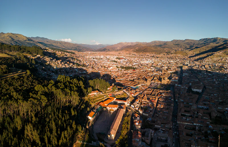 Golden-hour aerial of Cusco's rooftops and churches