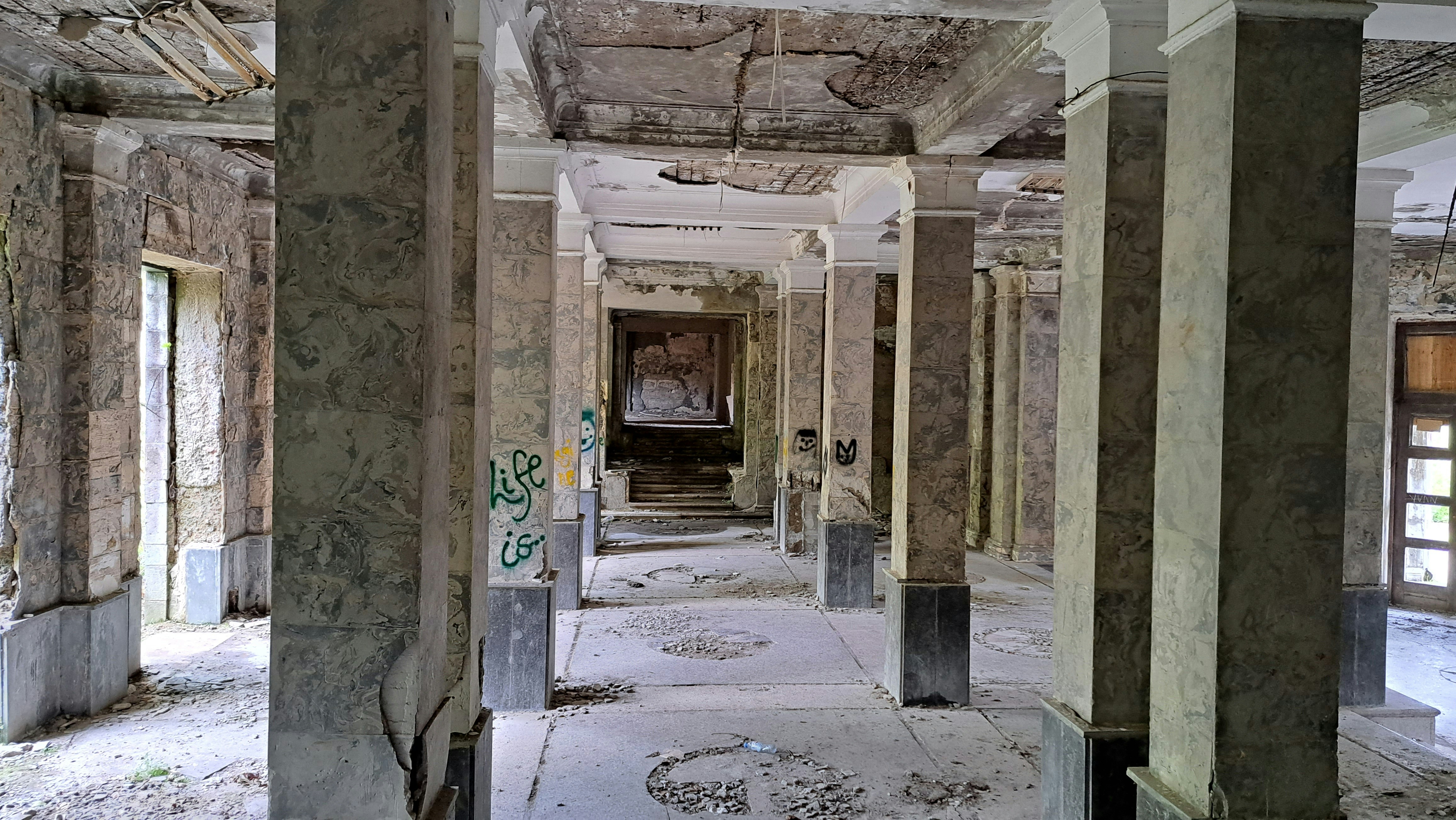 A long hallway in an abandoned building with graffiti on the walls