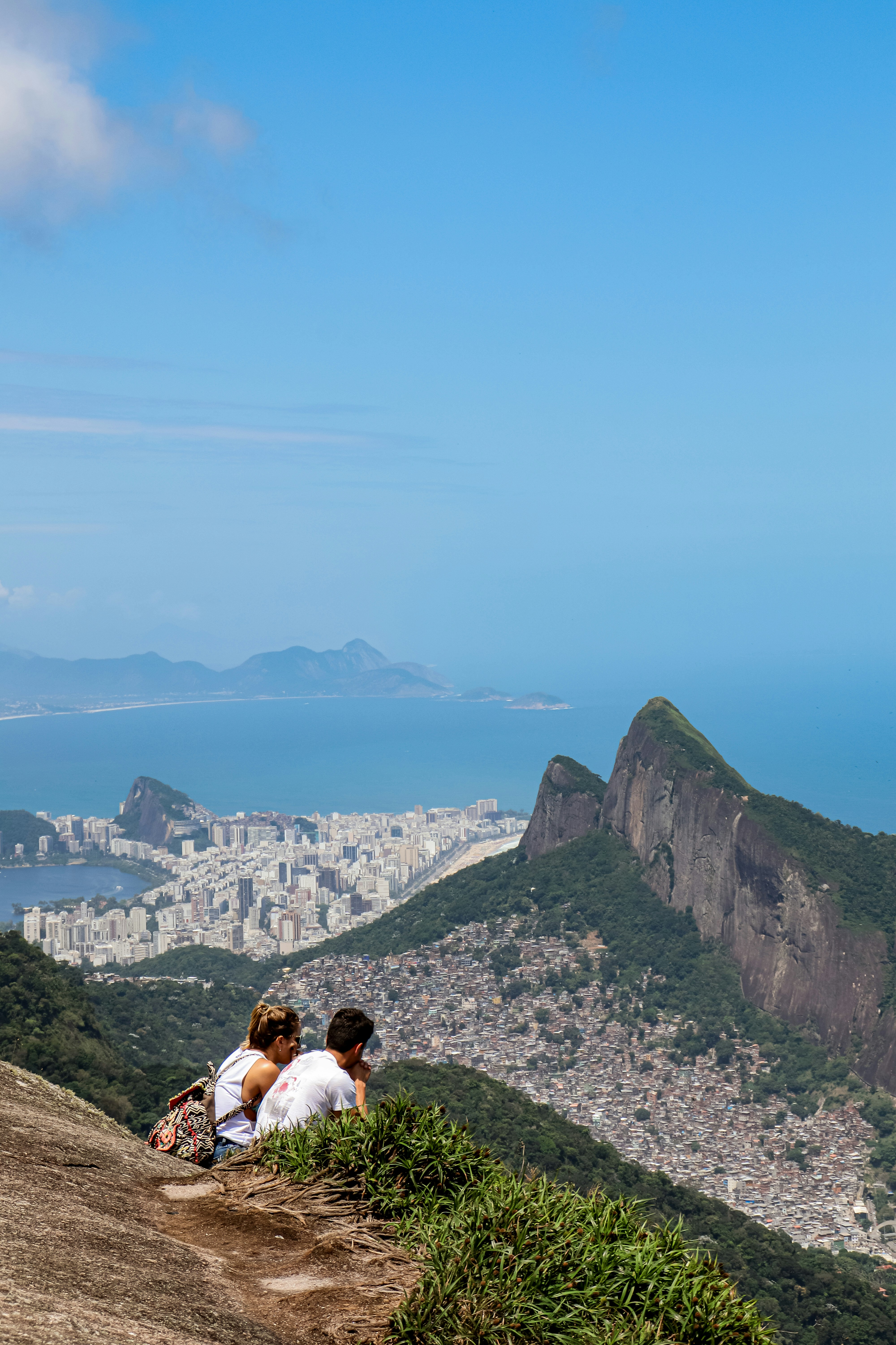 A couple of people sitting on top of a hill