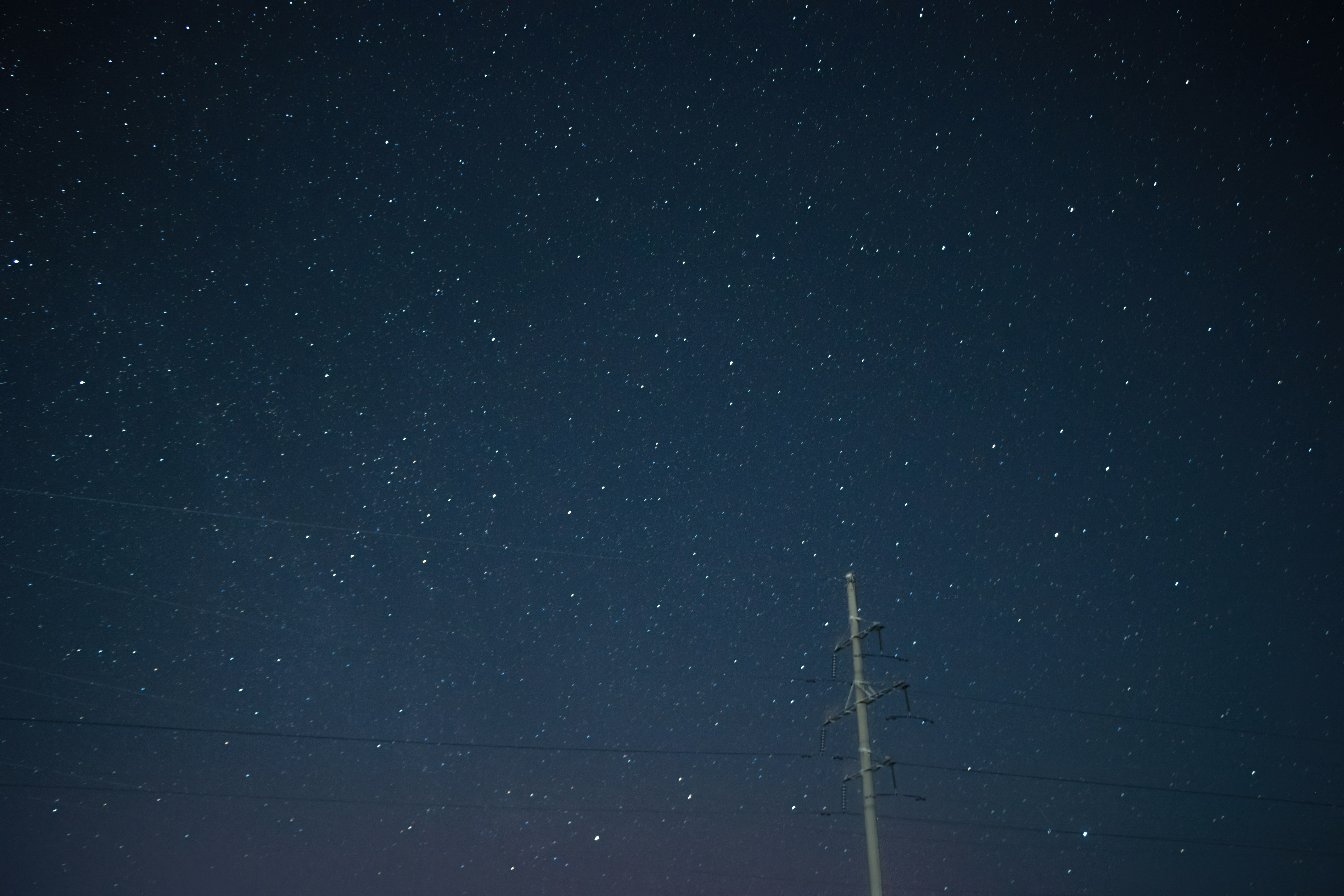 A night sky with stars and a rocket in the distance