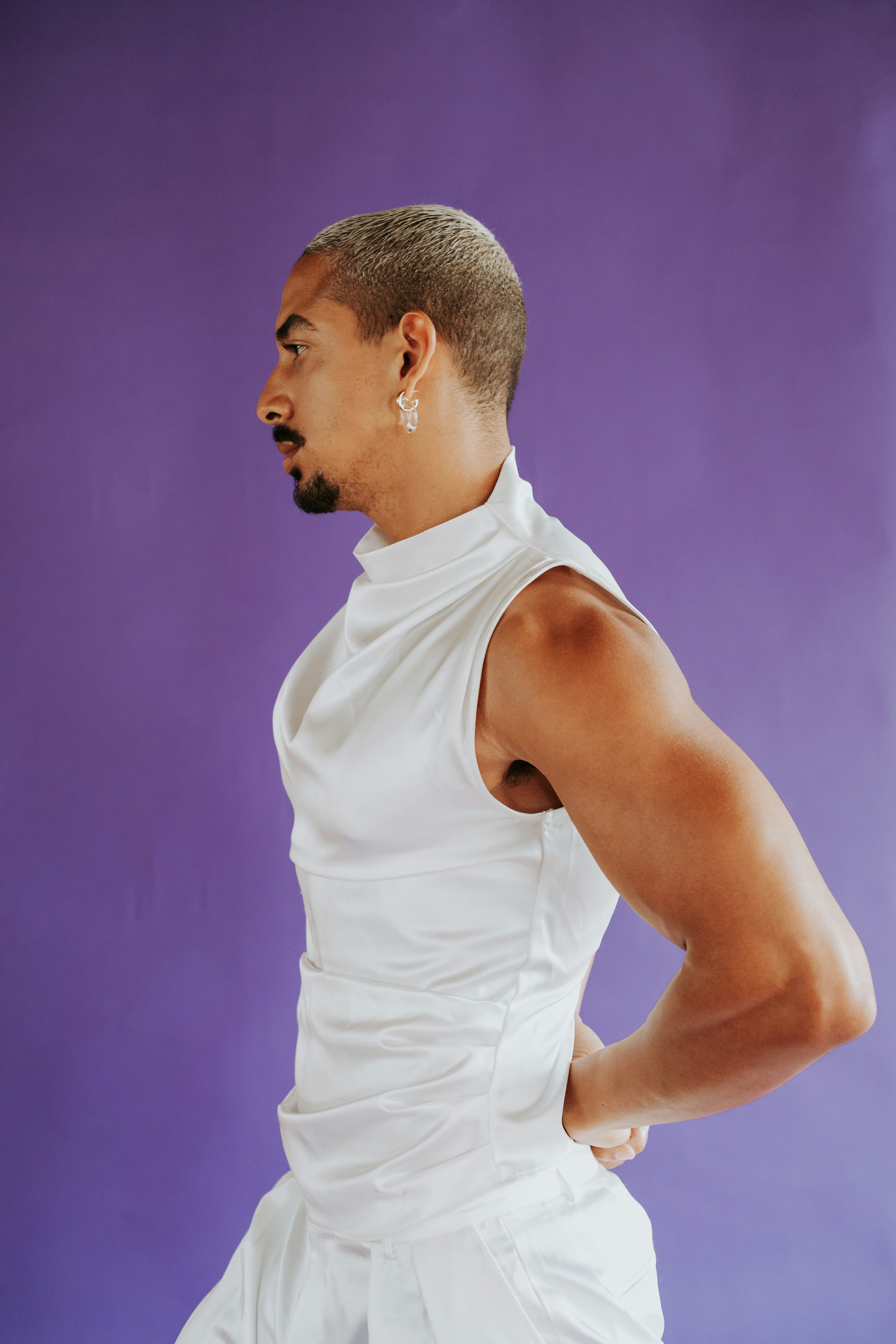 A man in a white outfit with his hands on his hips