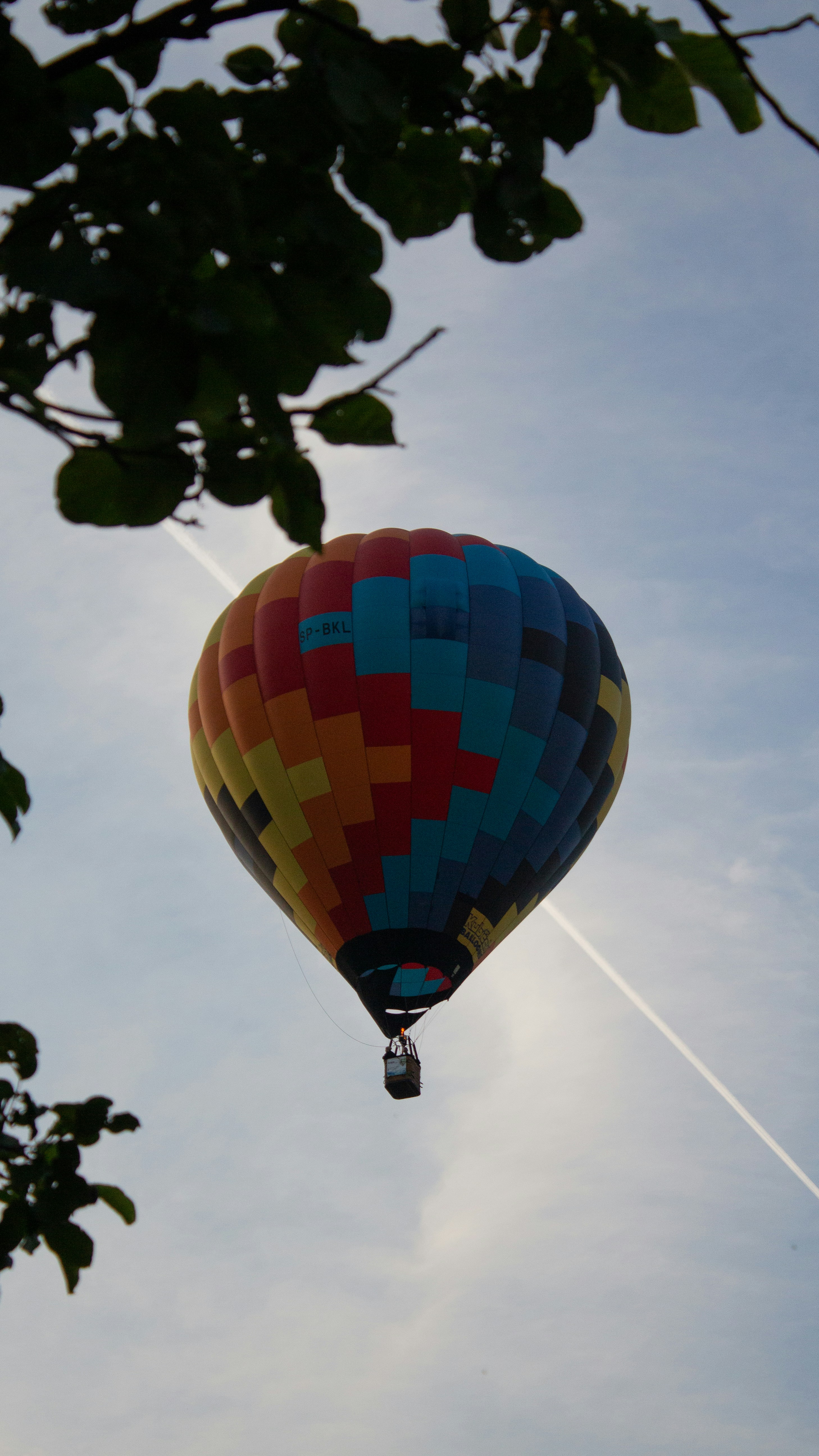 A colorful hot air balloon flying through a blue sky photo – Free Human ...