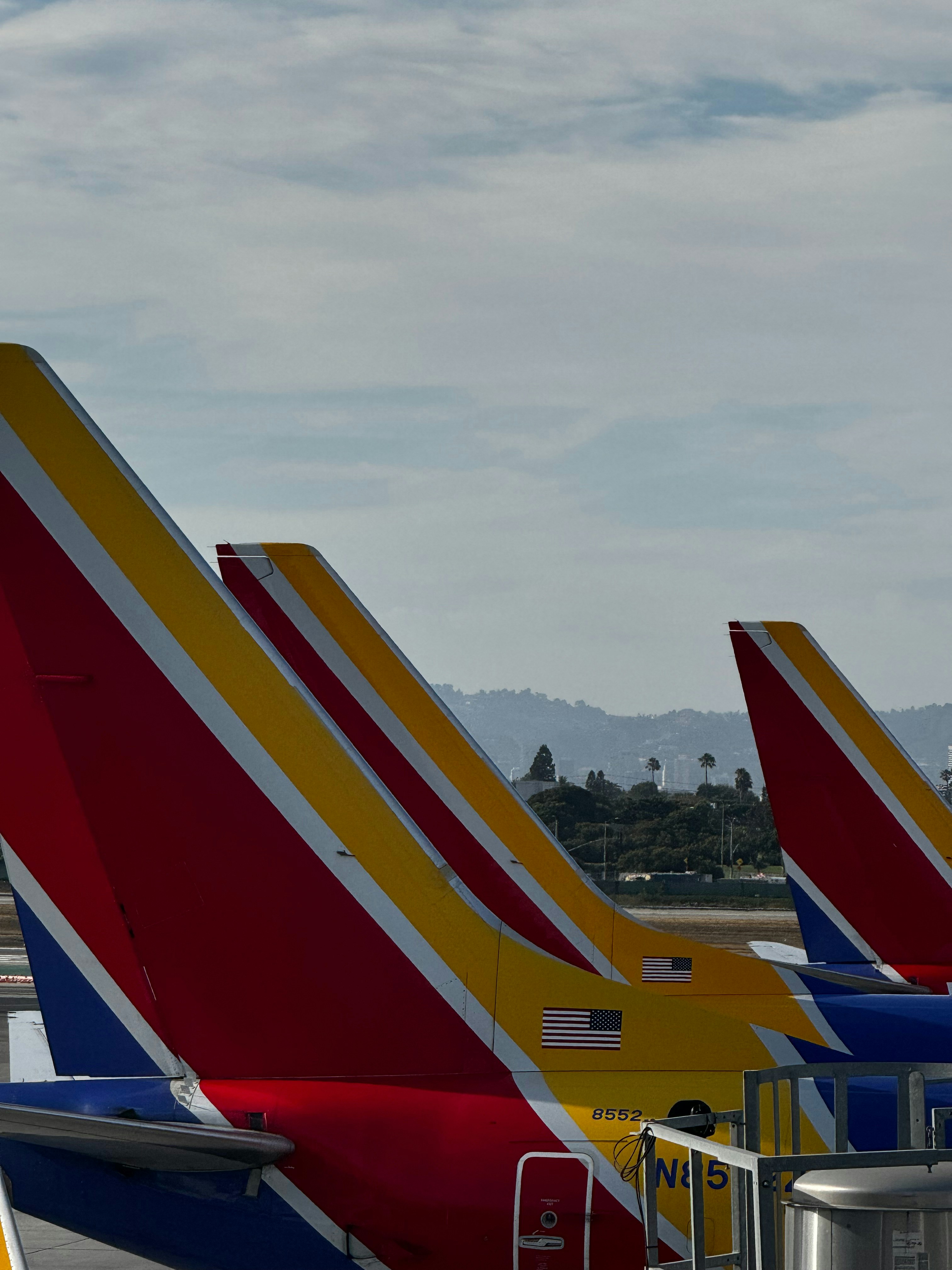 A row of airplanes parked on the tarmac at an airport
