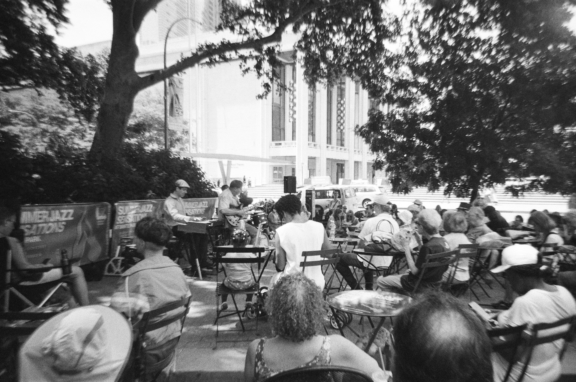 A group of people sitting at tables in front of a building