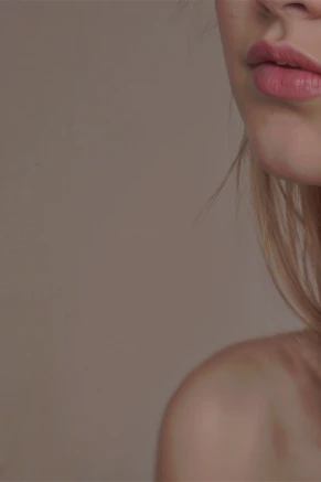 A woman with long blonde hair is wearing a pair of earrings