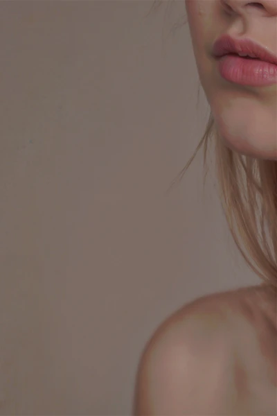 A woman with long blonde hair is wearing a pair of earrings