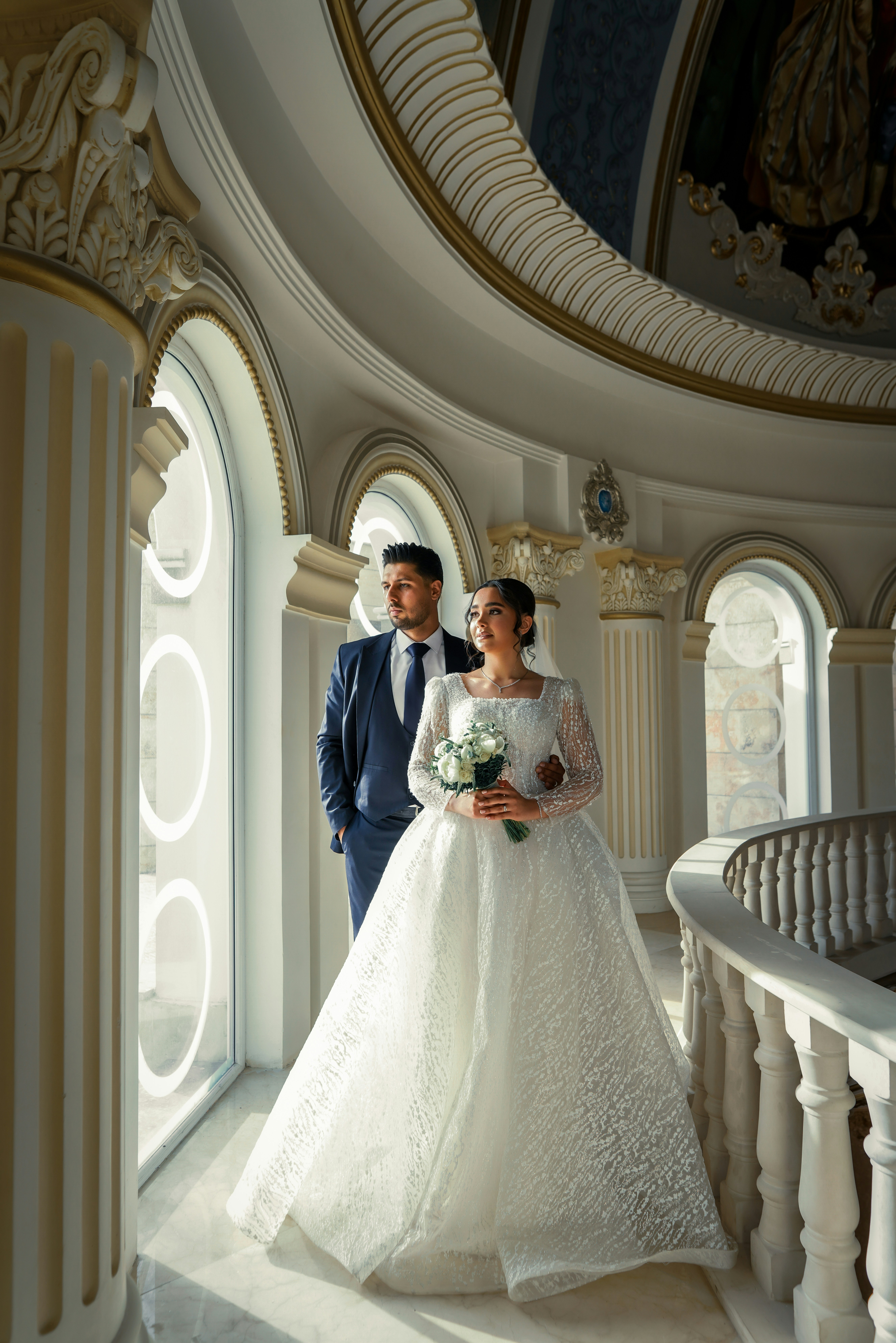 A bride and groom standing on a balcony