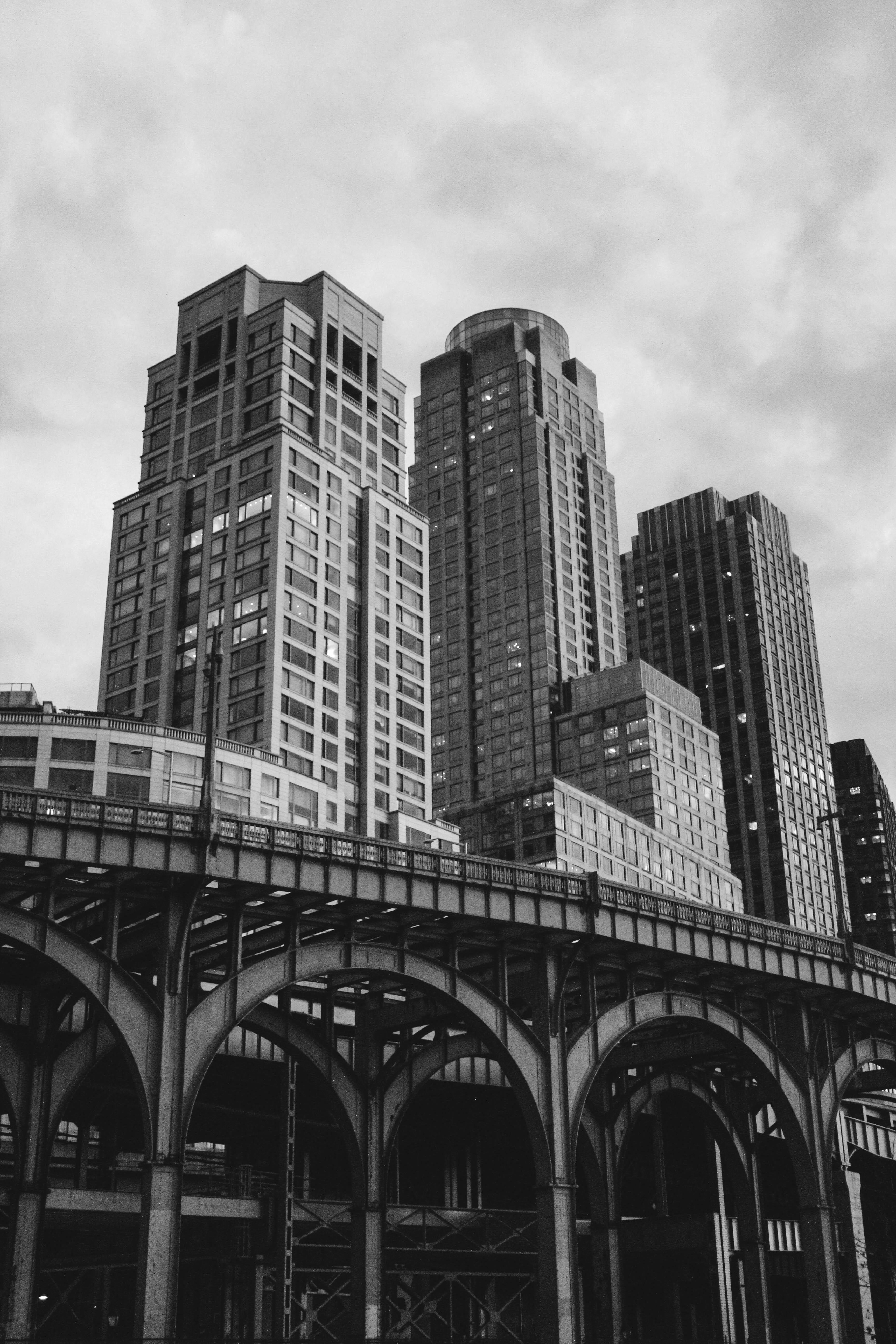 A black and white photo of a train on a bridge