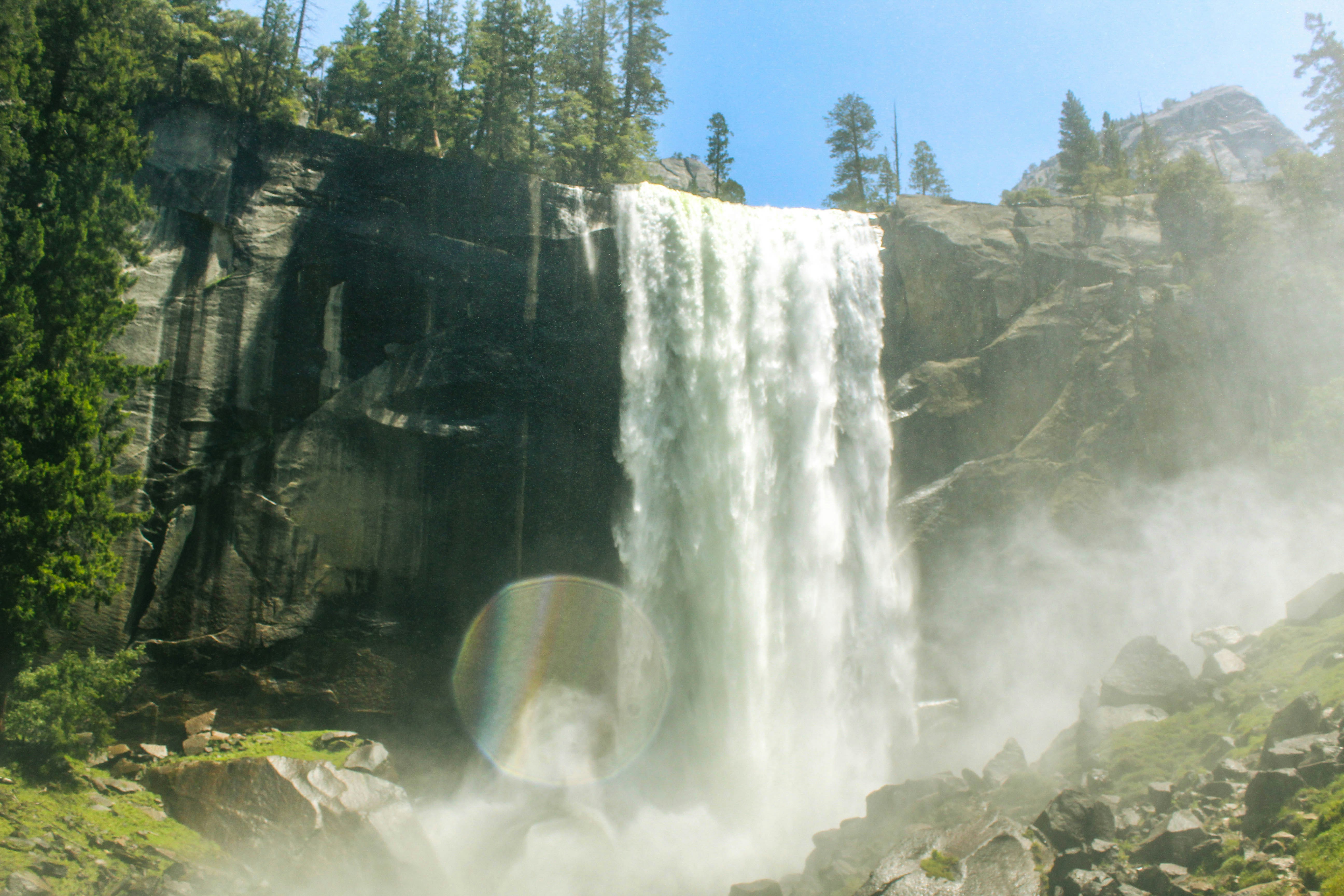 A waterfall with a rainbow in the middle of it