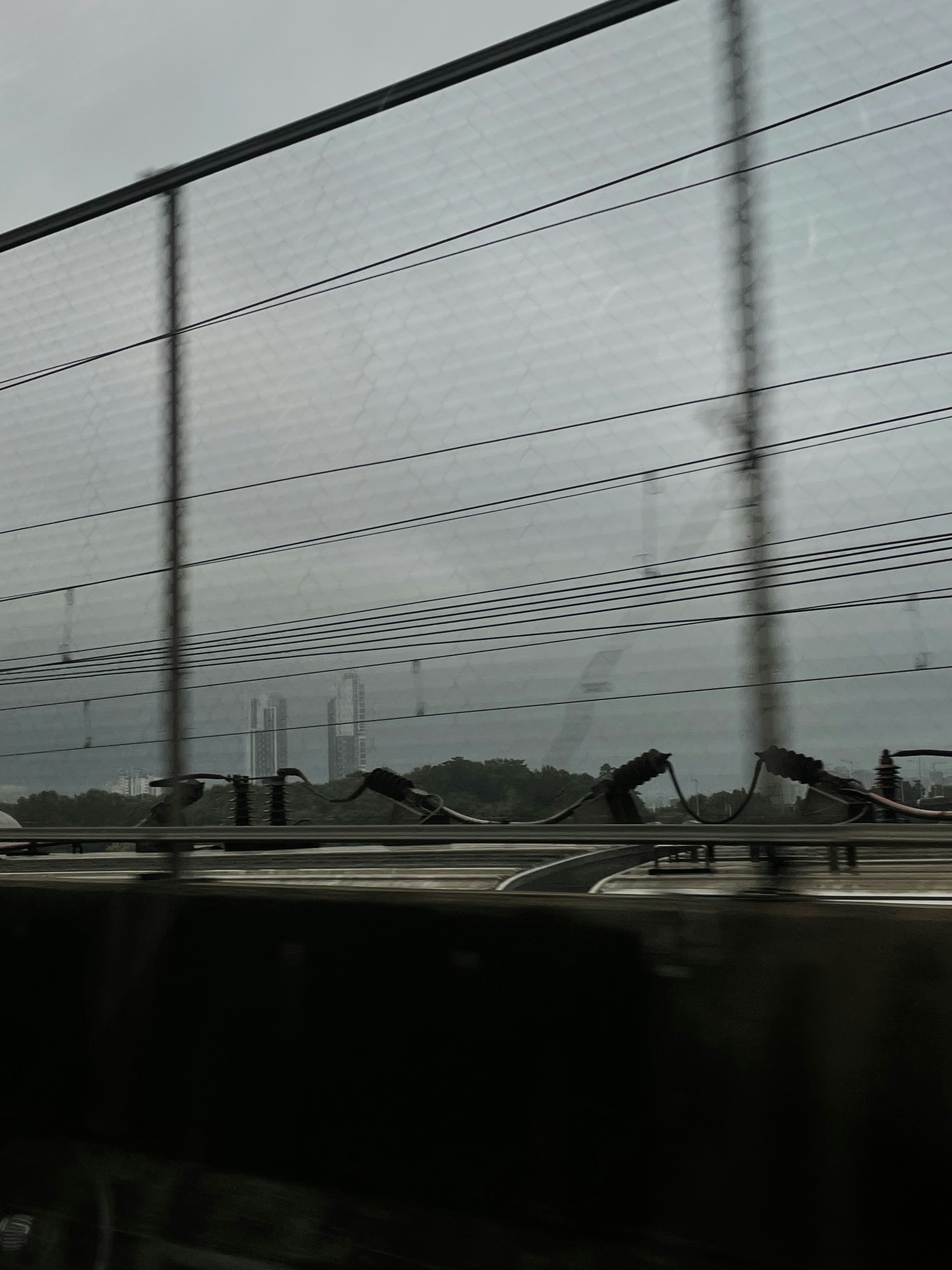 Um trem passando por uma cerca de metal alta