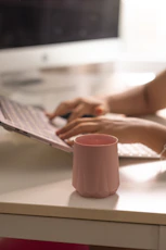A woman is typing on a computer at a desk