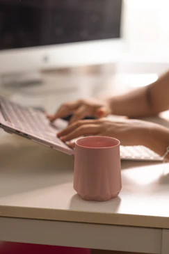 A woman is typing on a computer at a desk