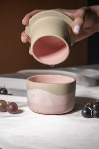 A person pouring a cup of coffee into a bowl