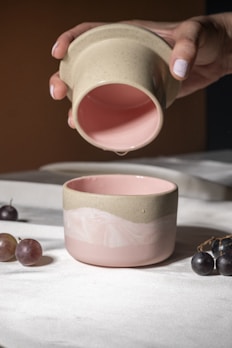 A person pouring a cup of coffee into a bowl