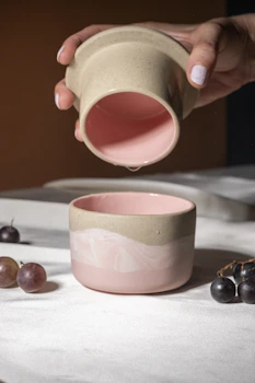 A person pouring a cup of coffee into a bowl
