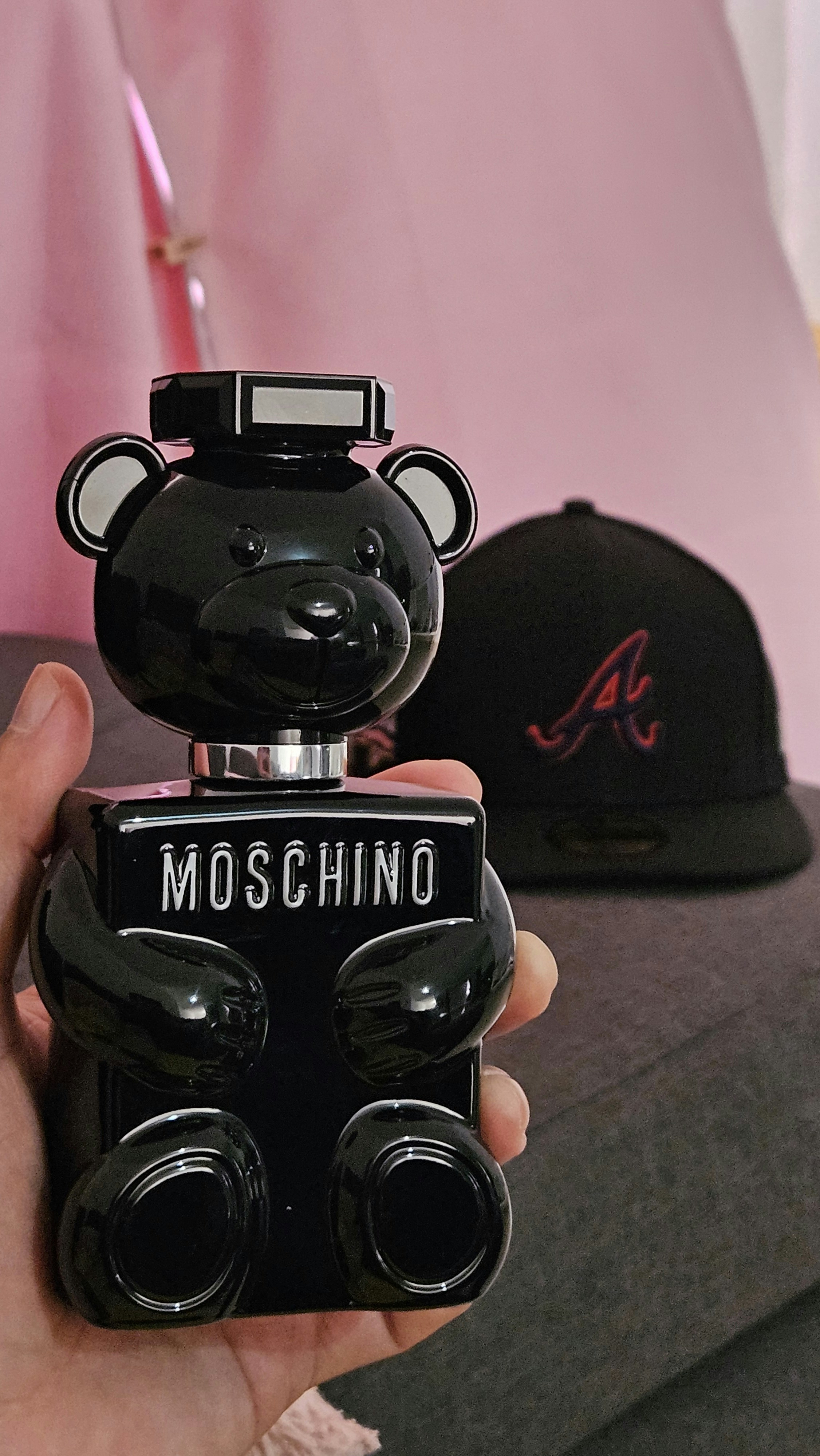 A person holding a black bear shaped bottle