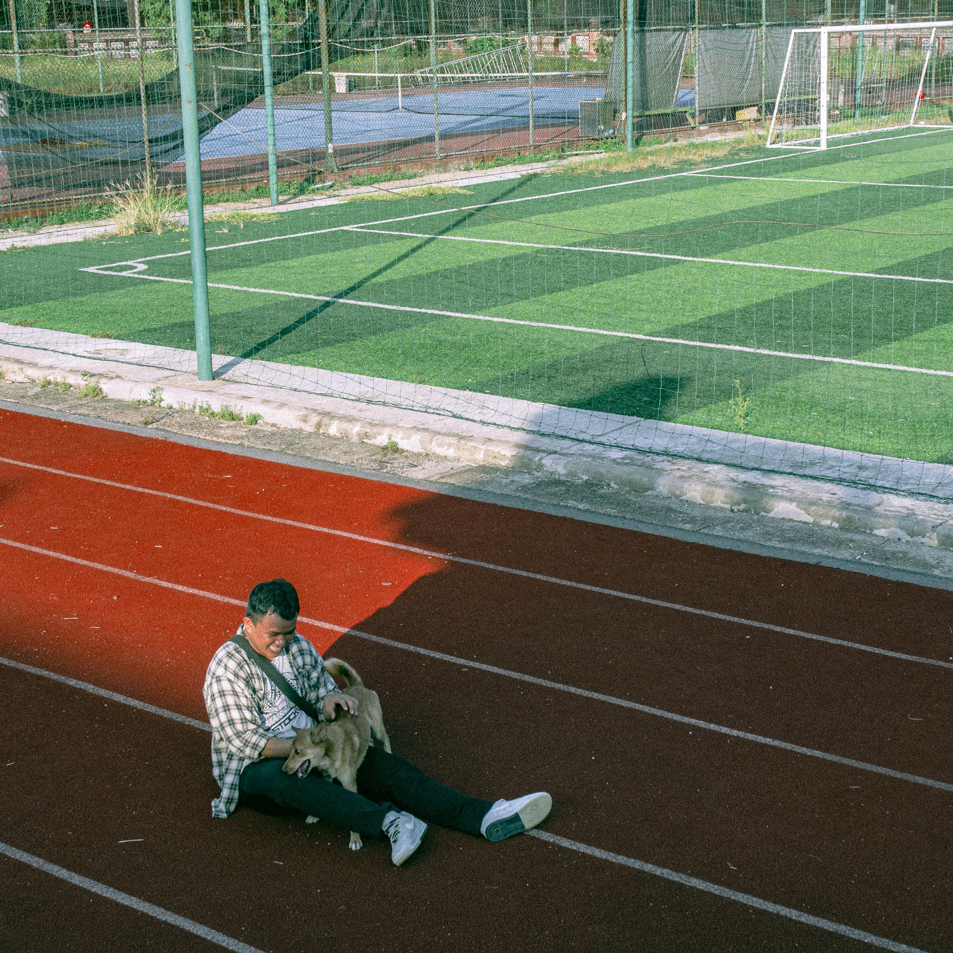 Boy playing with dog in Hue High School for the Gifted