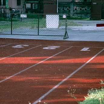 A boy is running on a track with a frisbee