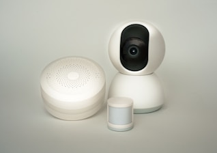 A white camera sitting next to a white container